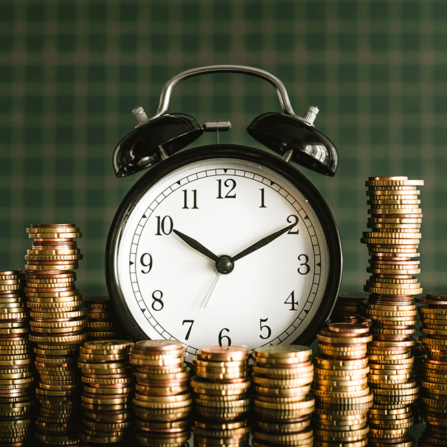 Image of clock with coins around it.
